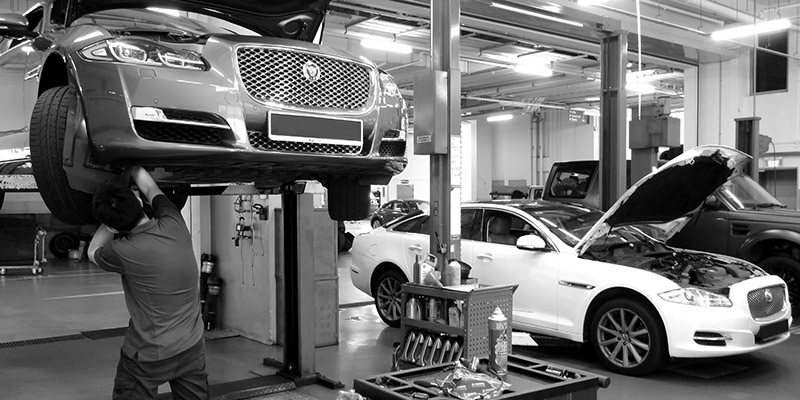 A Man Servicing A Jaguar's Bonnet